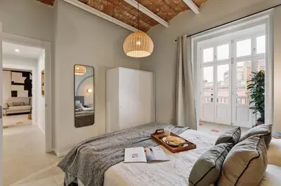 a dining room with a table and chairs and windows at Pacaya - 2 bedrooms, office and balcony in Eixample Dreta in Barcelona