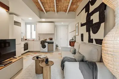 a living room with a bed and a large television at Pacaya - 2 bedrooms, office and balcony in Eixample Dreta in Barcelona