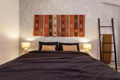 a bedroom with a bed and a red chair at Hassi - 2 bedrooms and terrace in Gràcia in Barcelona