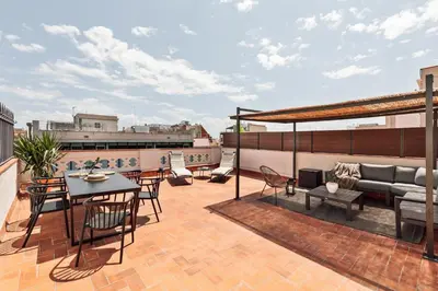 a patio with a table and chairs on a roof at Coipasa - 3 bedrooms and terrace in Eixample Dreta in Barcelona