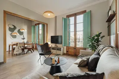 a bedroom with a living room with a couch and a table at Chixoy - 3 bedrooms and balcony in Eixample Dreta in Barcelona