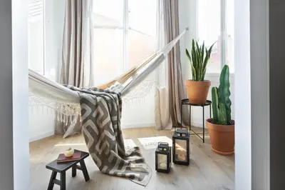 a living room with a hammock in front of a window at Anefis - 3 bedrooms and office in Gràcia in Barcelona