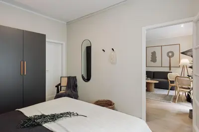 a kitchen with white cabinets and a black refrigerator at Izabal - 3 bedrooms and office in Eixample Esquerra in Barcelona