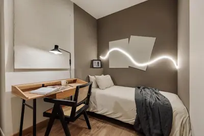a bedroom with a door leading to a bed and a sink at Walla - 3 bedrooms and balcony in Eixample Dreta in Barcelona