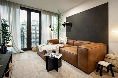 a living room with a couch and a large window at Tokashi - 2 bedrooms and balcony in Eixample Dreta in Barcelona