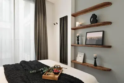 a bedroom with a bed with a large headboard at Lys - 2 bedrooms and pool in Eixample Esquerra in Barcelona