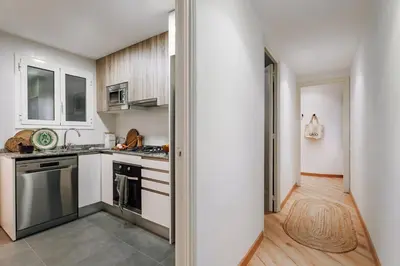 a kitchen with stainless steel appliances and wooden cabinets at Castellar - 2 bedrooms in Eixample Dreta in Barcelona