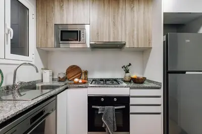a kitchen with a stove and a microwave at Castellar - 2 bedrooms in Eixample Dreta in Barcelona