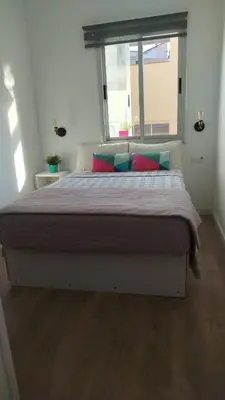a large bed in a room with a window at Apartamento CAMP NOU in Hospitalet de Llobregat
