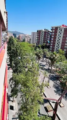 a balcony with a view of a park with trees and buildings at Alojamiento,Les corts in Barcelona