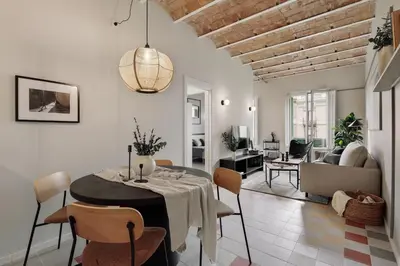 a dining room with a table and chairs and a living room at Pollock - 2 bedrooms and office in Eixample Dreta in Barcelona