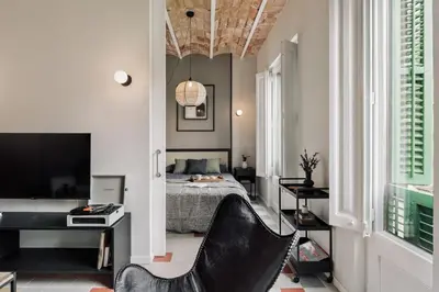 a kitchen and living room with white cabinets and a tile floor at Pollock - 2 bedrooms and office in Eixample Dreta in Barcelona