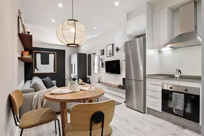 a kitchen with white cabinets and a dishwasher at Acconci - Studio and terrace in Eixample Esquerra in Barcelona