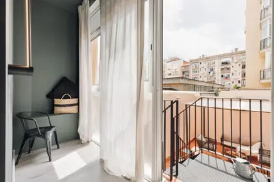 a living room with a couch and a tv at Acconci - Studio and terrace in Eixample Esquerra in Barcelona