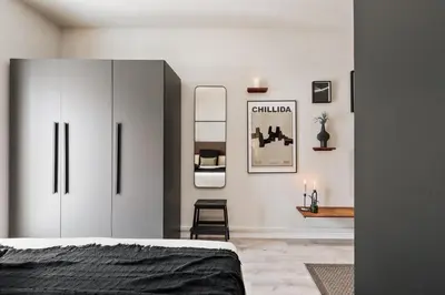 a kitchen with white cabinets and a stainless steel refrigerator at Acconci - Studio and terrace in Eixample Esquerra in Barcelona