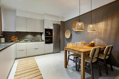 a kitchen with white cabinets and a wooden table at Padar - 2 bedrooms in Eixample Dreta in Barcelona
