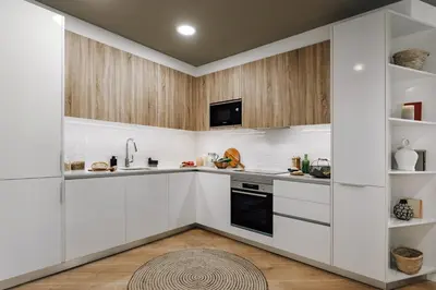 a kitchen with white cabinets and a black dishwasher at Montoro - 1 bedroom in Eixample Esquerra in Barcelona