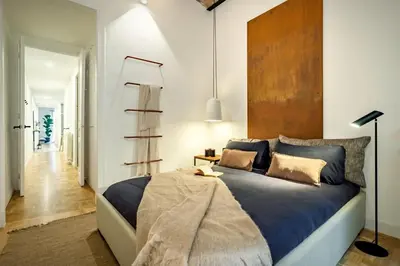 a bedroom with a bed and a table with a lamp at Akita - 2 bedrooms, terrace in Eixample Esquerra in Barcelona