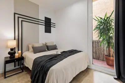 a bedroom with a bed and a desk next to a desk at Espriu - 2 bedrooms and balcony in Sant Antoni in Barcelona