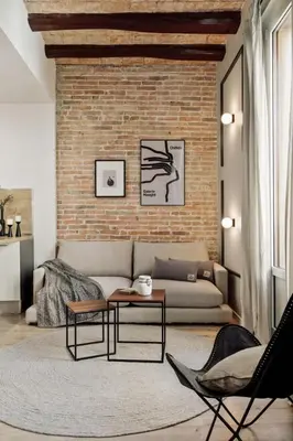 a living room with a couch and a brick wall at Espriu - 2 bedrooms and balcony in Sant Antoni in Barcelona