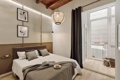a living room with a gray couch and a kitchen at Gava - 3 bedrooms and terrace in Sagrada Família in Barcelona