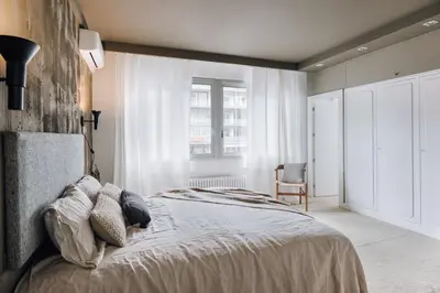 a white kitchen with wooden cabinets and a sink at Aran - 3 bedrooms in Eixample Esquerra in Barcelona
