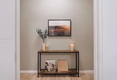 a console table with candles and a picture on the wall at Senes - 2 bedrooms in Eixample Esquerra in Barcelona