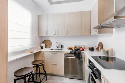 a kitchen with white cabinets and stools in it at Feliu - 2 bedrooms in Eixample Dreta in Barcelona
