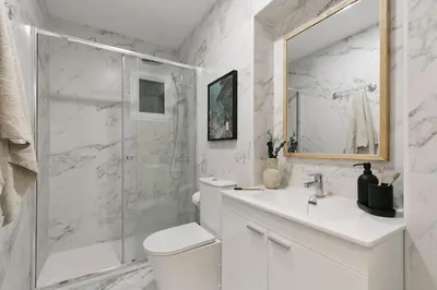 a white kitchen with white cabinets and appliances at Equense - 2 bedrooms in Sant Gervasi in Barcelona