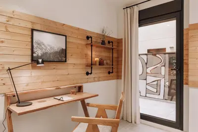 a bedroom with a large bed with a wooden headboard at Tibi - 2 bedrooms and office in Eixample Esquerra in Barcelona