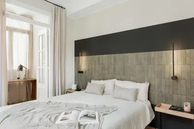 a bedroom with a large bed with a wooden headboard at Mourene - 3 bedrooms in Eixample Dreta in Barcelona