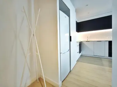a room with a hallway with a door and a kitchen at Apartamento céntrico, moderno, Terrassa Rambla in Terrassa