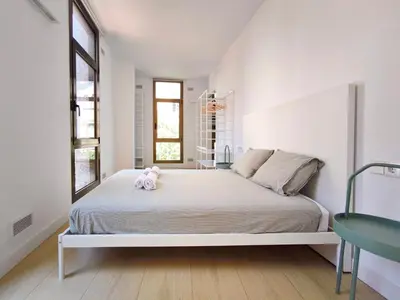 a white bedroom with a bed with a stuffed animal on it at Apartamento céntrico, moderno, Terrassa Rambla in Terrassa