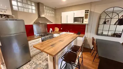 a kitchen with a wooden counter top and a refrigerator at Charmant appartement à Vila de Gracia Barcelone in Barcelona
