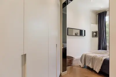 a bedroom with a bed with two lamps and a mirror at Halea - 3 bedrooms w/ terrace in Eixample Esquerra in Barcelona
