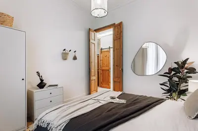 a bedroom with a large bed with a wooden headboard at Tella - 2 bedrooms and office in Eixample Esquerra in Barcelona