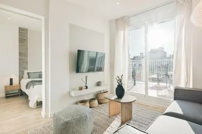 a white bedroom with a large bed with gray pillows at Spiaggia - 1 bedroom and terrace in Sant Gervasi in Barcelona