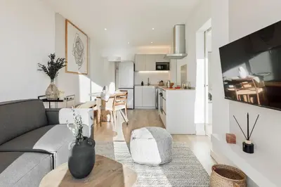 a kitchen and living room with a table and a couch at Spiaggia - 1 bedroom and terrace in Sant Gervasi in Barcelona