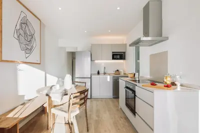 a living room with a couch and a kitchen at Spiaggia - 1 bedroom and terrace in Sant Gervasi in Barcelona