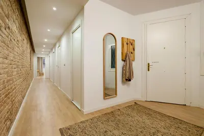 a kitchen with stainless steel appliances and a long hallway at Kuta - 2 bedrooms and balcony in Sant Gervasi in Barcelona