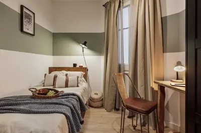 a small bedroom with a bed and a chair at Kuta - 2 bedrooms and balcony in Sant Gervasi in Barcelona