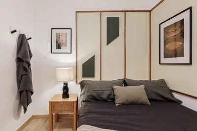 a bedroom with a bed with green and white stripes at Demir - 2 bedrooms and office in Vila de Gràcia in Barcelona