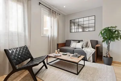 a living room and kitchen with a couch and a table at Ceret - 1 bedroom in Gòtic in Barcelona