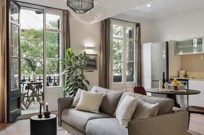 a living room with a couch and a kitchen at Paestum - Studio and balcony in Eixample Esquerra in Barcelona