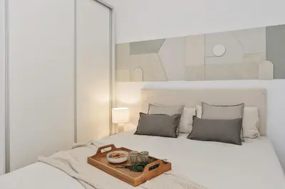 a white bed with a tray of food on it at Tramonti - 2 bedrooms and terrace in Sant Antoni in Barcelona