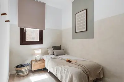 a bedroom with a bed with a night stand and a window at Tramonti - 2 bedrooms and terrace in Sant Antoni in Barcelona