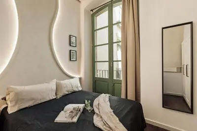 a bedroom with a bed with two mirrors on the wall at Ilani - 2 bedrooms in El Gòtic in Barcelona