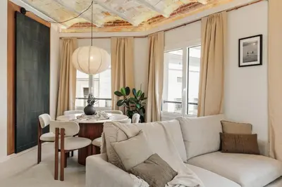 a white kitchen with white cabinets and black stools at Gandoc - 3 bedrooms and terrace in Sants in Barcelona