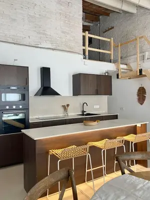 a kitchen with a counter and some chairs in it at New penthouse duplex by the sea in Masnou