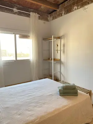 a bedroom with a white bed and two windows at New penthouse duplex by the sea in Masnou